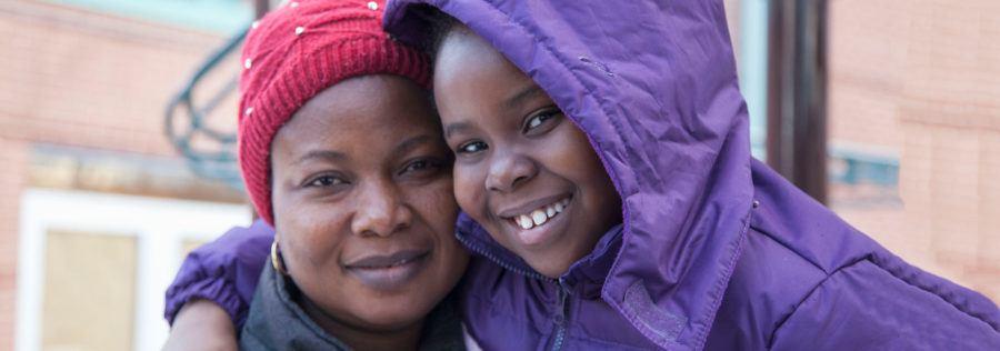 Mom and daughter in winter coats smiling