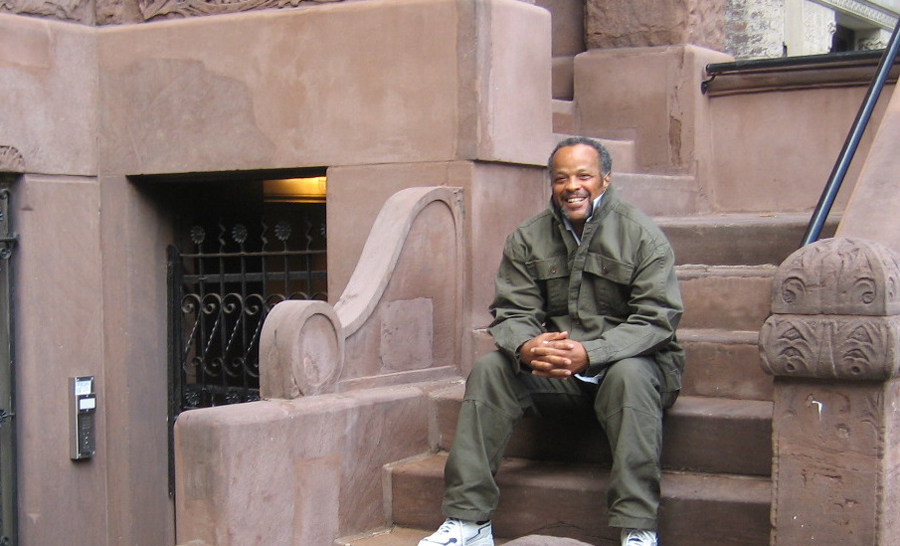 Smiling man sitting on apartment. steps