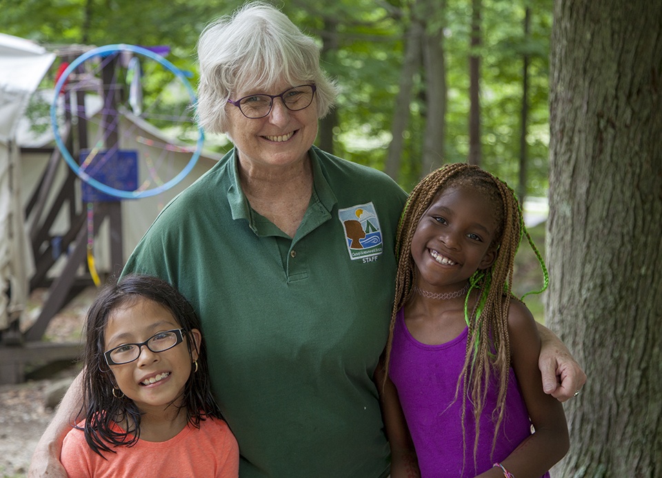 Two young girls posing with Camp Director Bev McEntarfer