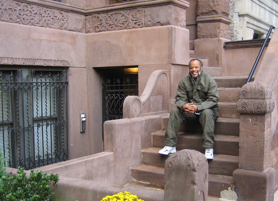 A man sitting on the steps of Coalition Houses