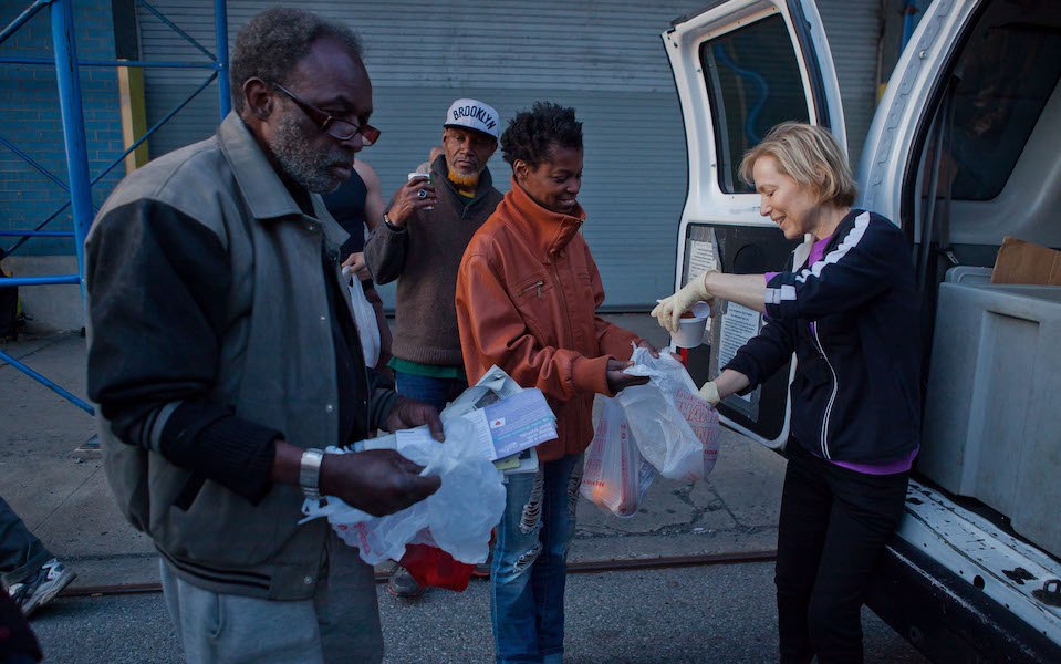 Woman handing out food at Grand Central Food Program