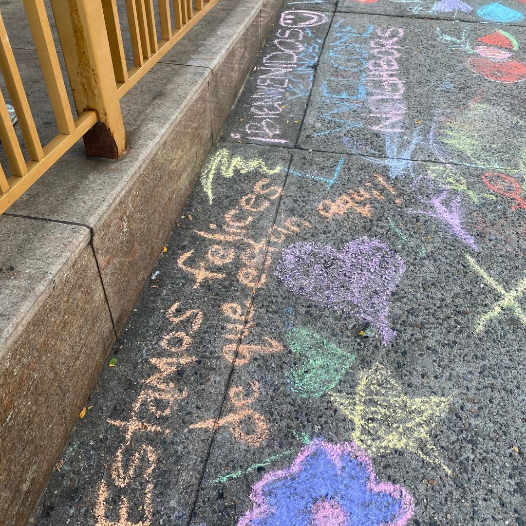 Midtown Open Hearts members came together for a community art event outside a shelter to write welcoming chalk messages.