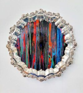 Circle with intricate silver frame and colorful vertical lines.